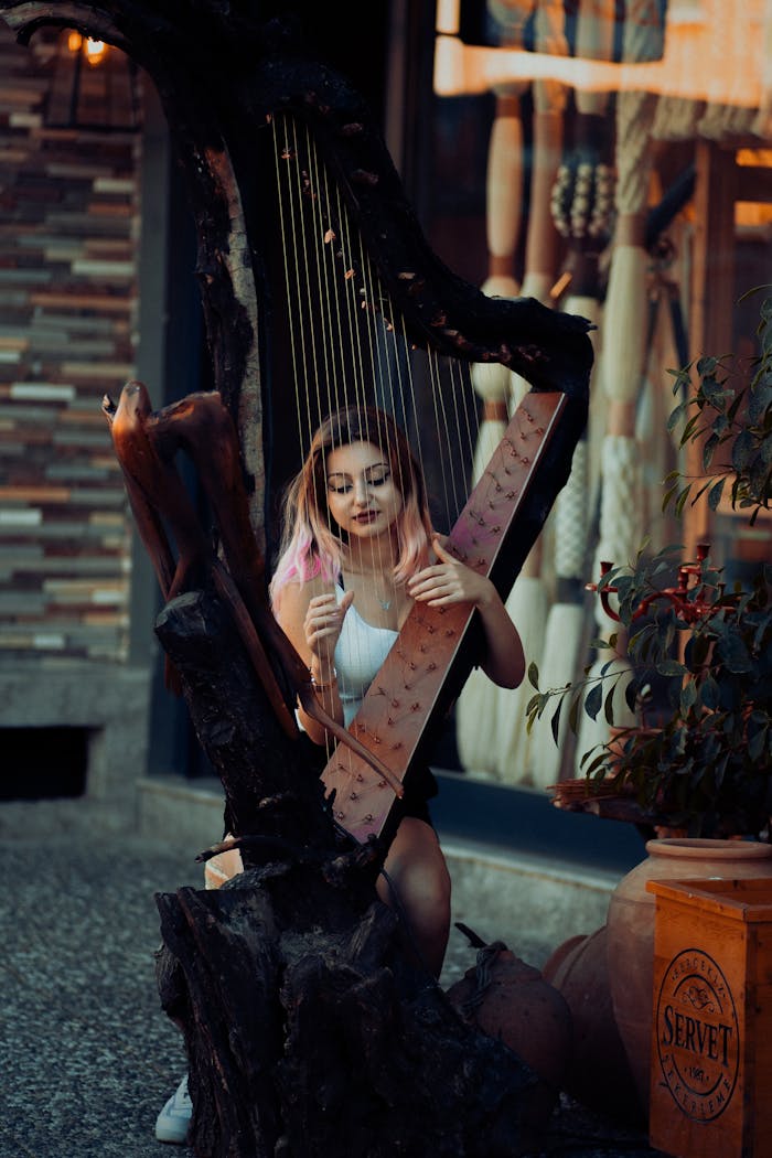A woman plays a unique sculpted harp outdoors, blending art and music.